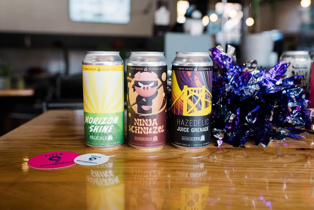 Local craft beer cans and Title 9 coasters on the bar