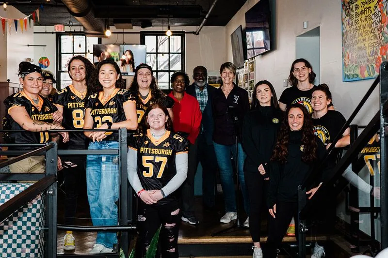 The Title 9 team and friends on the stairs at the grand opening